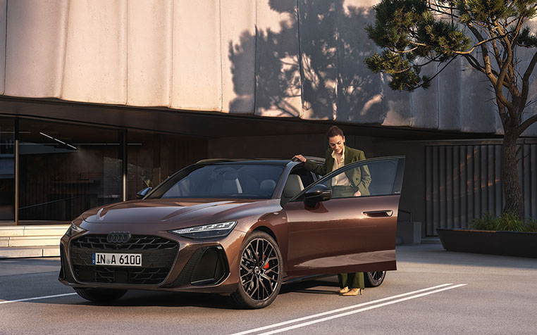 Frau steht neben einem Audi A6 Avant. 